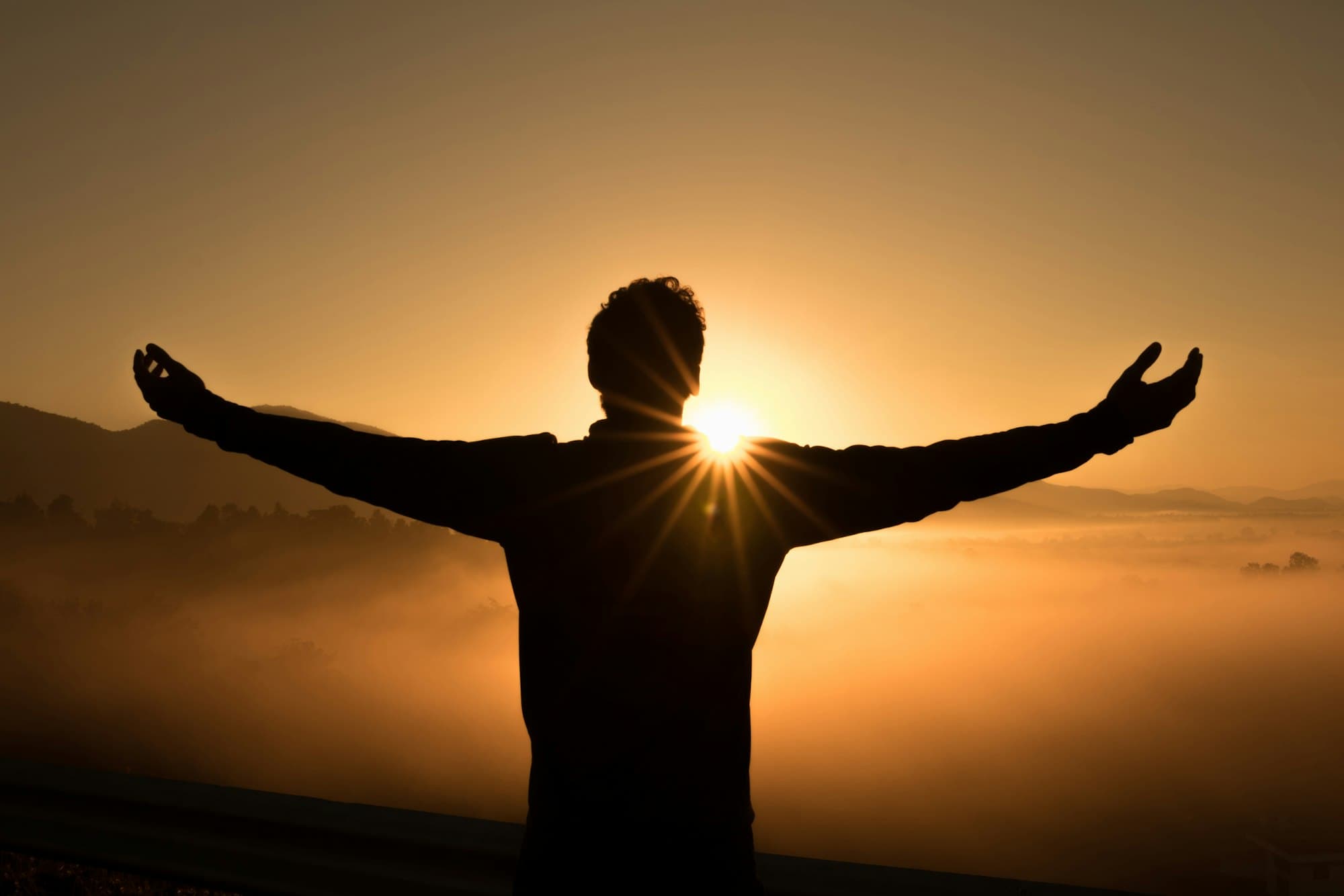 A silhouette at sunrise on a quiet horizon.